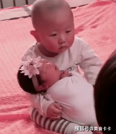 2岁哥哥抱着妹妹拍新生儿照, 表情生无可恋, 宝宝： 真心笑不出来